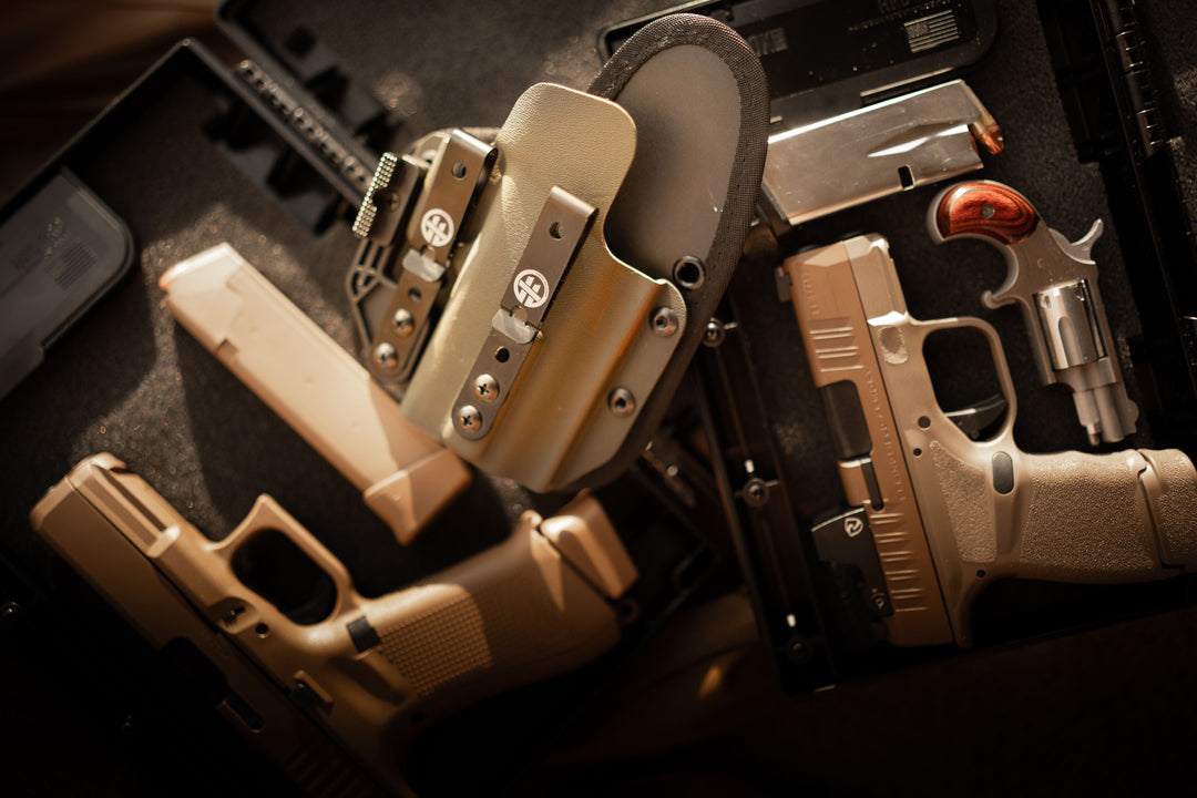 OMNICARRY IWB holster with Glock and Springfield Hellcat pistols stored in a STOPBOX Pro, demonstrating safe firearm storage and multi-fit holster compatibility.
